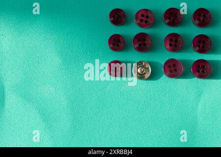 Buttons laid out in a row on a turquoise background. In the style of flat lay. Stock Photo