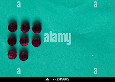 Buttons laid out in a row on a turquoise background. In the style of flat lay. Stock Photo