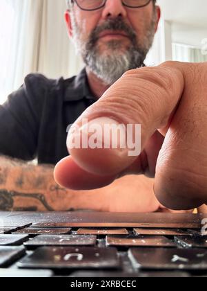 laptop camera view of man clicking clickbait or signing in in a website. Finger in close up and keyboard. User in background. One worker typing on computer. Moern businessman using notebook online Stock Photo
