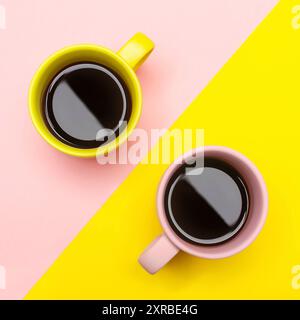 Flat lay top view of a two coffee cups with pink and yellow. Stock Photo