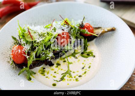 Vegan warm asparagus-broccoli salad with dill aioli, vegan cheese. Delicious healthy vegeterian food served for lunch on a table in modern gourmet cui Stock Photo