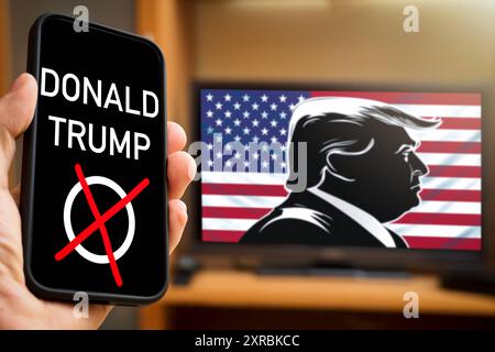 July 9, 2024: Symbolic image of elections in the USA. A smartphone shows an election cross with the name Donald Trump, on the TV a silhouette of Trump in front of the US flag. PHOTOMONTAGE *** Symbolbild Wahlen in den USA. Ein Smartphone zeigt ein Wahlkreuz mit den Namen Donald Trump, auf dem Fernseher eine Silhouette von Trump vor der Flagge der USA. FOTOMONTAGE Stock Photo