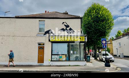 An artwork by mystery street artist Banksy appeared above a fish and chip shop in Walthamstow, east London, UK Stock Photo