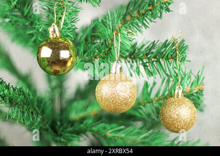 New year concept idea. Golden balls on Christmas tree isolated on gray background. Preparation for new year celebration. Stock Photo