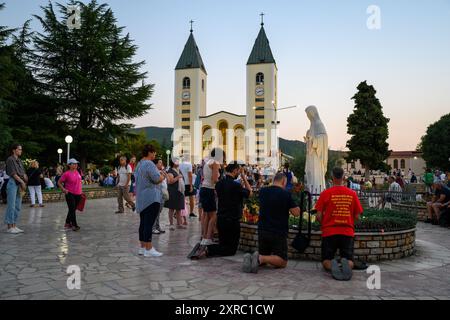 People praying around the statue of the Queen of Peace near the St James Church in Medjugorje, Bosnia and Herzegovina. Stock Photo