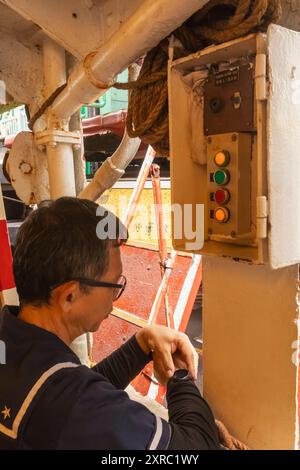 China, Hong Kong, Hong Kong Island, The Star Ferry, Crewman Checking Time on Wristwatch Stock Photo