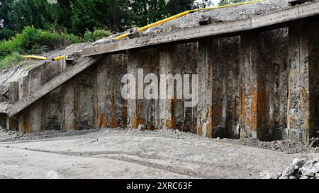 A construction site featuring an exposed concrete retaining wall and foundation work. The photo shows the industrial and rugged nature of the construc Stock Photo