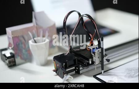3d printer draws with a pencil on paper, blurry Stock Photo