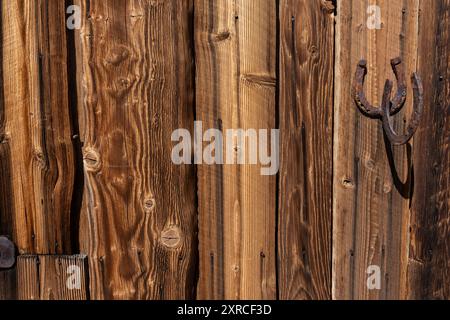 Weathered and cracked wooden planks with rusty old nails and rusty horseshoes Stock Photo