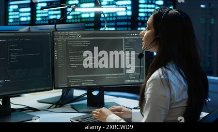 Data center call center agent responsible for providing logistics support to businesses. Worker in server farm establishment oversees infrastructure systems and communicates with engineers, camera A Stock Photo