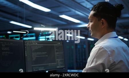 Data center system administrator responsible for installation of networking equipment solving tasks. IT employee at work doing maintenance on server room hardware, camera B Stock Photo