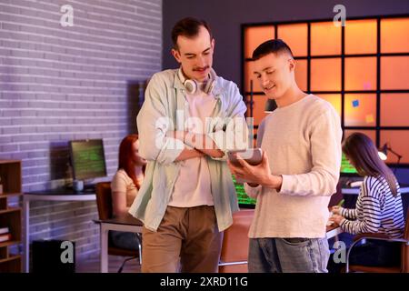 Male programmer with tablet computer in office at night Stock Photo