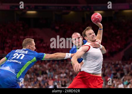 Lille, France. 9th Aug, 2024. Mathias Gidsel (R) of Denmark shoots during the men's semifinal of handball between Slovenia and Denmark at the Paris 2024 Olympic Games in Lille, France, on Aug. 9, 2024. Credit: Meng Dingbo/Xinhua/Alamy Live News Stock Photo