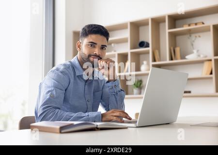Positive handsome young Arab businessman posing for business portrait Stock Photo