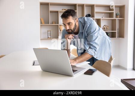 Thoughtful business project manager man working at laptop in office Stock Photo