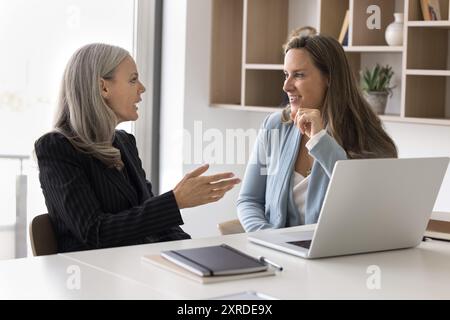 Two diverse female business colleagues discussing creative ideas Stock Photo