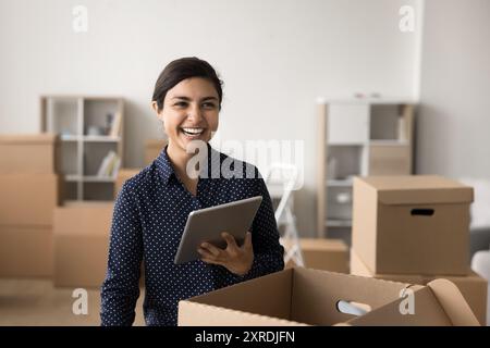 Happy Indian businesswoman using tablet working in warehouse Stock Photo