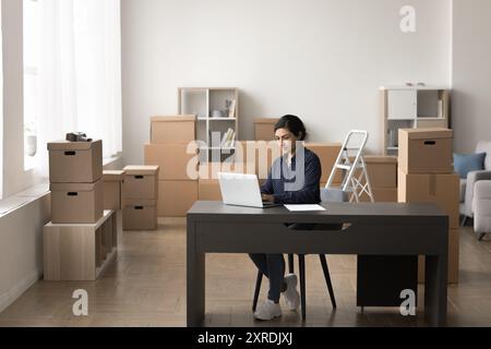 Warehouse worker, small business owner working on laptop Stock Photo