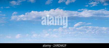 Replacement panoramic skyline- view of vivid white clouds against bright blue summer sky background. clear gradient from darker cyan to a light white. Stock Photo