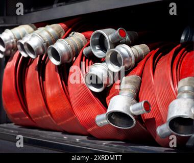 Coiled fire hoses as typically seen on a fire truck appliance. Fire engine hoses are an essential firefighting apparatus in extinguishing blazes. Stock Photo