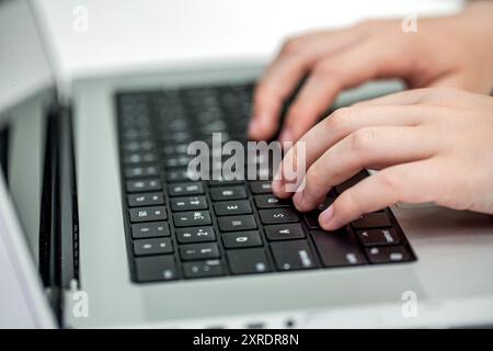 Close up of man hands typing on laptop computer keyboard. Man's hands typing. Closeup of a man's finger pressing on the enter button of laptop Stock Photo