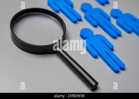 Close-up image of magnifying glass and figurines. Know your customer concept. Stock Photo