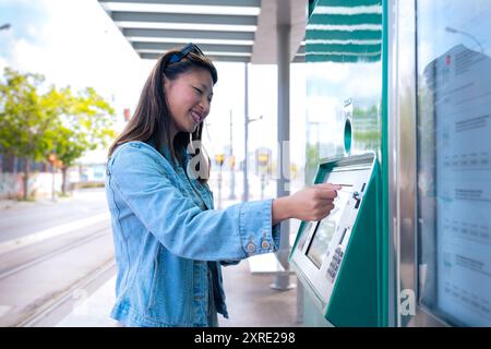 Chinese woman is a buying a ticket for the subway at a ticket booth in ...