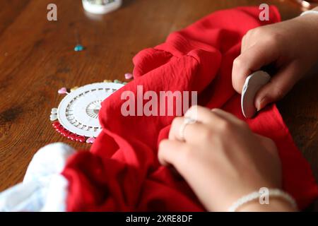 Teenage girl marking textile fabric with chalk - craft skills, sew Stock Photo