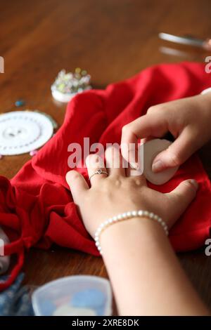 Teenage girl marking textile fabric with chalk - craft skills, sew Stock Photo