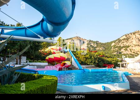 Waterpark Slide Pool Mountain - A blue waterslide at a waterpark in a mountainous region. Stock Photo