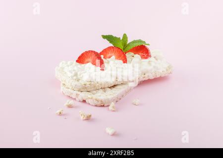 Rice cake topped with cottage cheese and strawberries on pink background Stock Photo