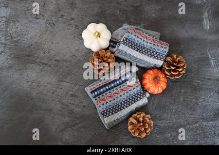 Warm knitted socks and fall season decorations on dark background with space for text. Autumn hobby concept. Stock Photo