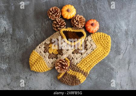 Warm knitted socks and fall season decorations on dark background with space for text. Autumn hobby concept. Stock Photo