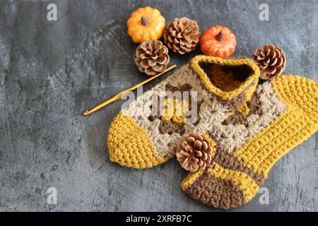 Warm knitted socks and fall season decorations on dark background with space for text. Autumn hobby concept. Stock Photo