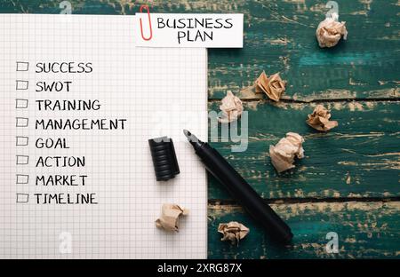 A business plan is written on a piece of paper with a marker. The plan includes goals, action items, and a market analysis Stock Photo