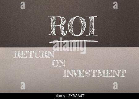 A chalkboard with the word ROI written on it. The word ROI is written in white and the letters are drawn in black. The image is of a gray and white ba Stock Photo