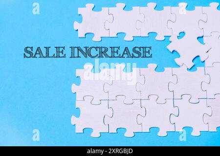 A puzzle with the words sale increase written on it. The puzzle pieces are scattered and the words are written in a jagged, messy font. Concept of urg Stock Photo