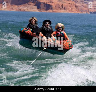 Lake Powell, Arizona, USA. 13th Aug, 2020. Kids enjoy water sports on Lake Powell while being towed by speedboat. Lake Powell is a man-made reservoir on the Colorado River in Glen Canyon National Recreation Area and straddles 2 western states Utah and Arizona. It is a major vacation spot, stretching from the beginning of the Grand Canyon in Arizona to southern Utah, Glen Canyon National Recreation Area is graced with scenic views, unique geology and 10,000 years of human history. Activities include boating, fishing, hiking. Lake Powell, is the second largest man made lake in the United States Stock Photo