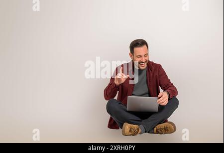 Cheerful young male freelancer discussing business plans and strategies while video conferencing over laptop. Happy businessman gesturing and planning Stock Photo