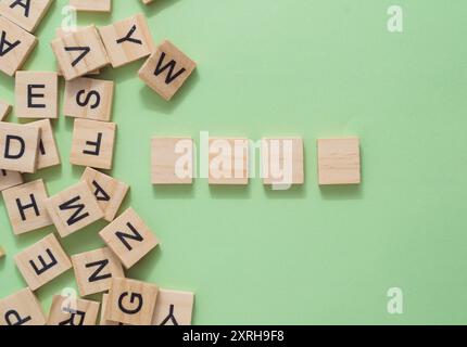 A pile of wooden letters. The letters are scattered across the image, with some overlapping each other. Scene is one of disarray and confusion Stock Photo