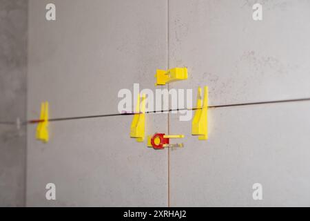 Tile installation using plastic leveling clips and wedges. Ensuring a smooth Stock Photo