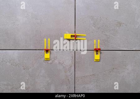 Tile leveling system with plastic clips and wedges in action. Ensures precise Stock Photo