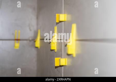 Tile installation using plastic leveling clips and wedges. Ensuring a smooth Stock Photo