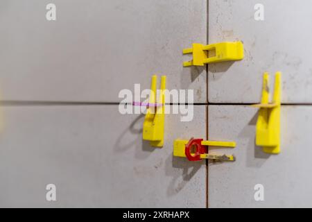 Detailed view of tile leveling system in use with plastic clips and wedges. Stock Photo