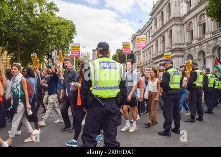 London, UK. 10th Aug, 2024. Police officers observe protesters in Westminster during the march against Reform UK leader Nigel Farage and the far right. The march was part of the ongoing protests against the far right, fascism and racism following the anti-immigration riots that swept across the UK. Credit: SOPA Images Limited/Alamy Live News Stock Photo