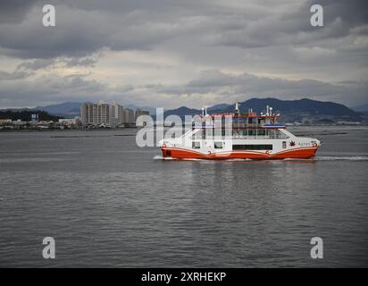 Landscape with scenic view of the JR West Miyajima Maru Ferry boat cruising from Miyajimaguchi Pier to Miyajima island Terminal in Japan. Stock Photo
