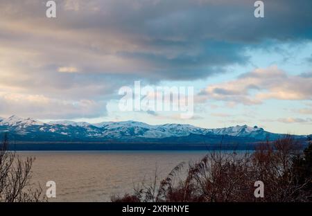 Evening sky with dramatic clouds over mountains, lake and trees. Dramatic sunset over the lake Stock Photo