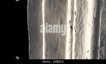 Textured white lime wall with subtle imperfections and shadow play. Stock Photo