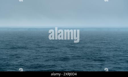 A23a Iceberg Incredible Beautiful View from Ship. Dark Blue Ocean Drake Passage Fog in Distance Scenic Antarctica Floating Huge Ice Stock Photo