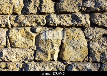 Detailed view of a weathered stone wall made from large boulders. Stock Photo